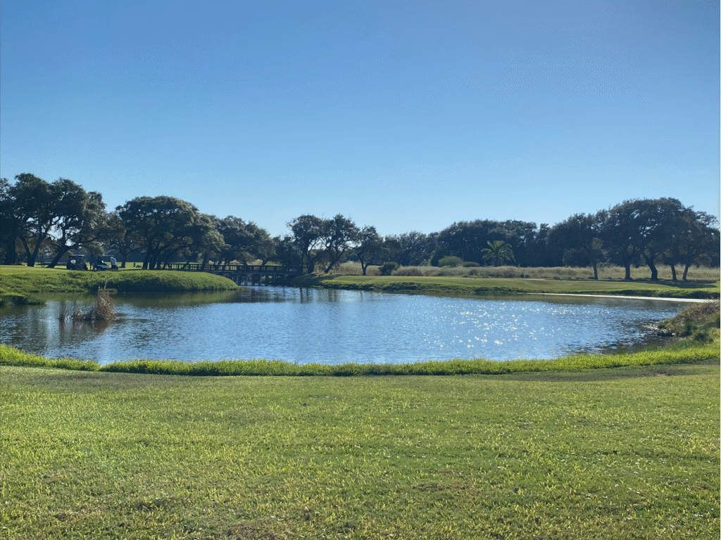 Aerial view of Rockport Country Club golf course with homes along the fairway under Texas coastal skies